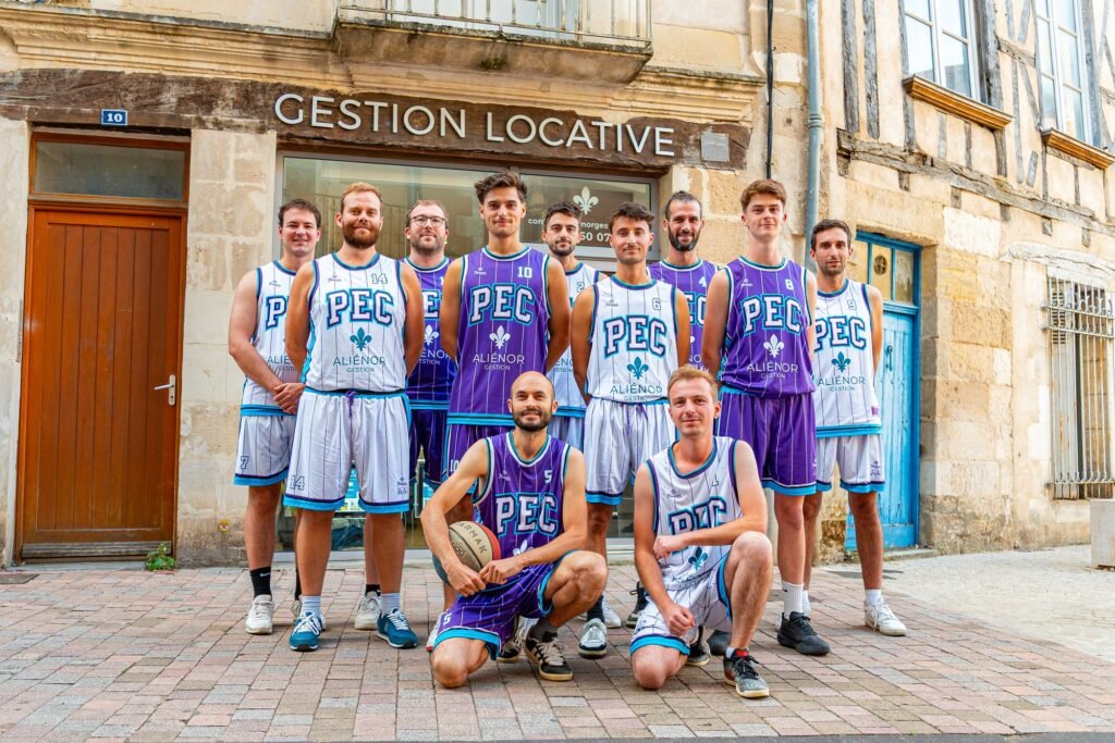 L'équipe seniors du PEC Basket Poitiers, en maillots Aliénor Gestion, devant l'agence rue des Vieilles Boucheries